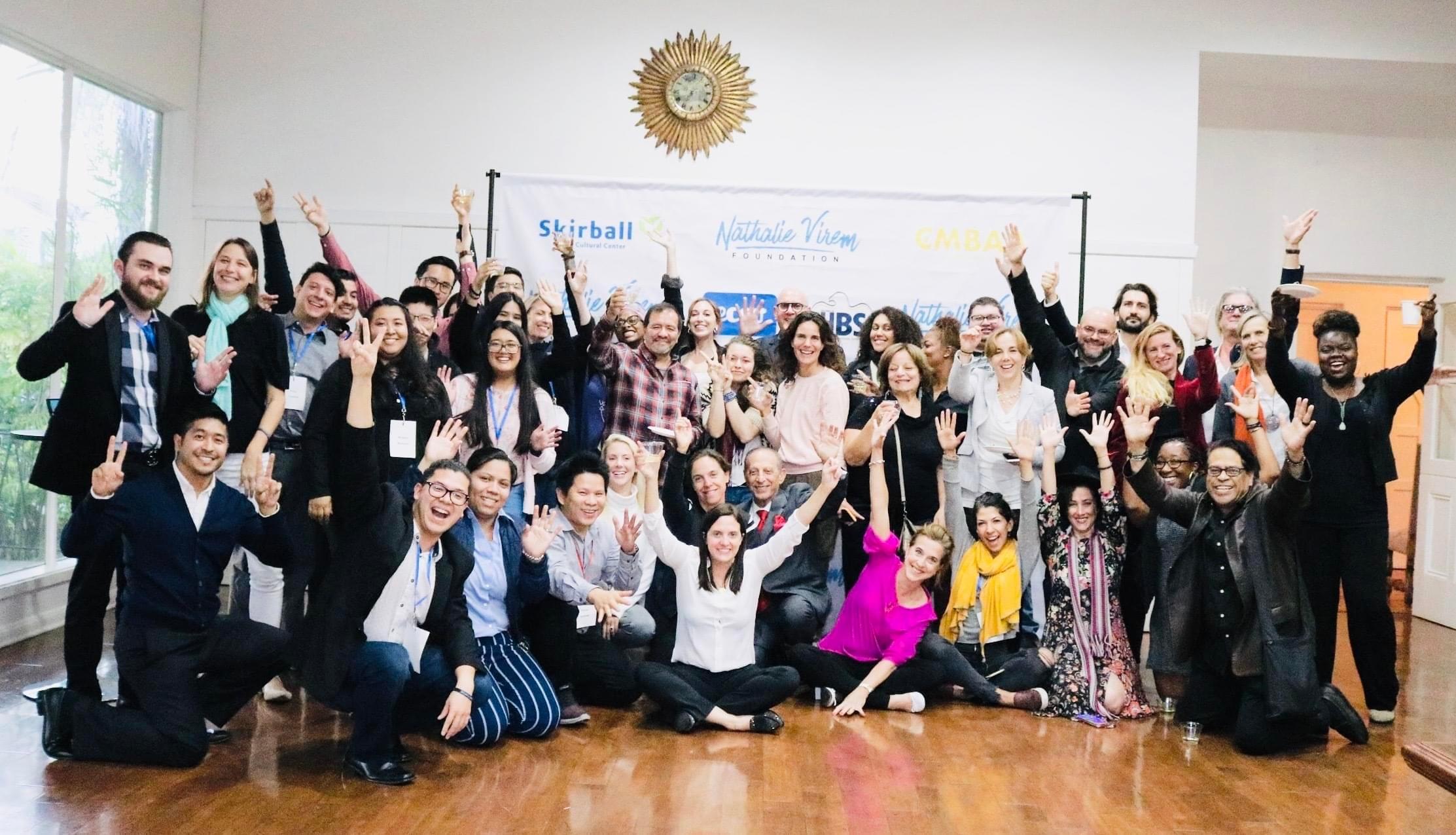 Picture of our 2019 scholarships winners with their hands up and Nathalie Virem in the middle