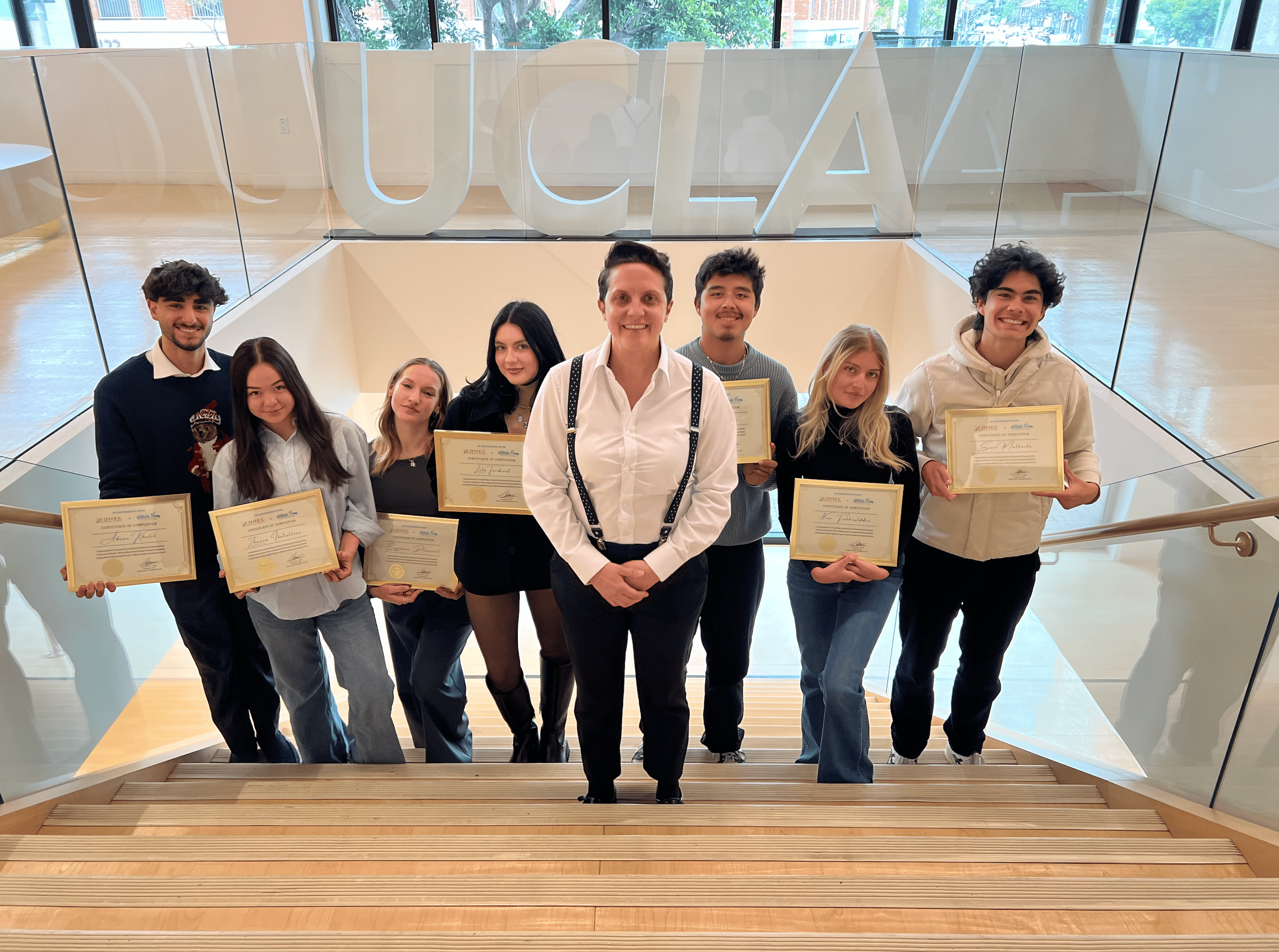 Picture of UCLA Extension Scholarship winners of 2025 holding their certificate of completion with Nathalie Virem in the middle